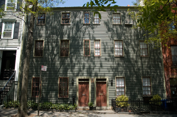 Trees cast their shadows on a symmetrical pair of homes.