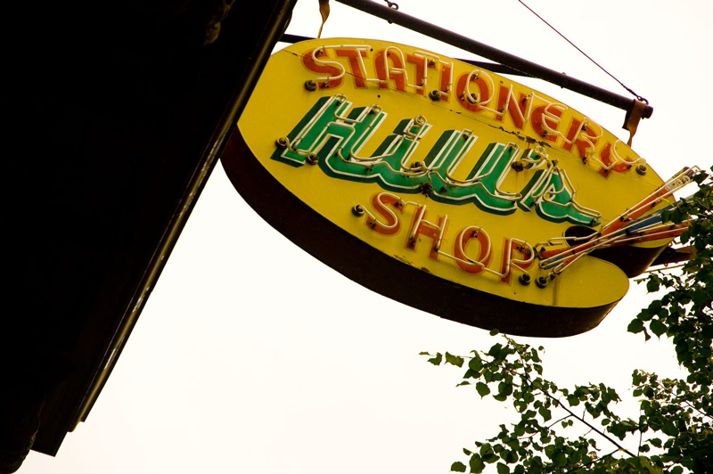 Painter's brushes and a palette decorate a neon sign for a stationer.