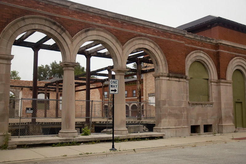 Open-air collonnade, with boarded windows.